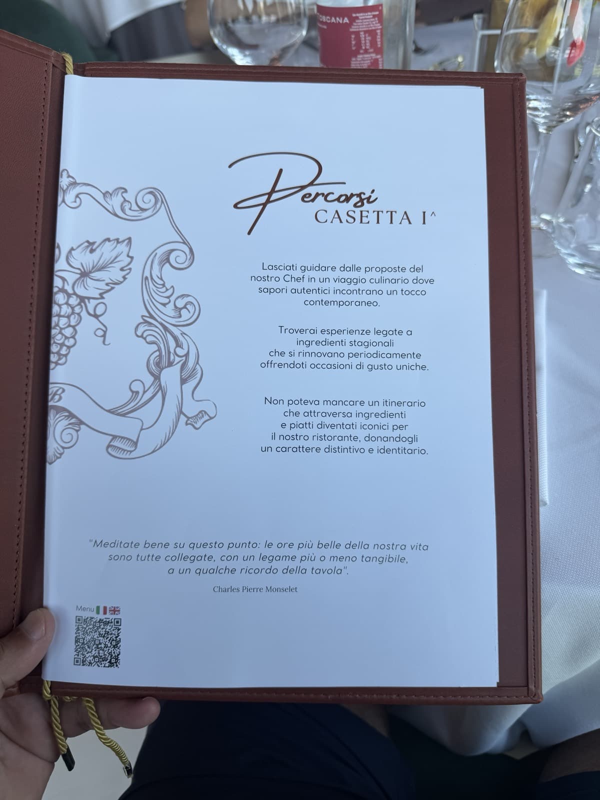 The Percorsi page introducing the kitchen's tasting routes in Italian, drawn around a vine motif, with a quotation and a QR code for allergens at the foot