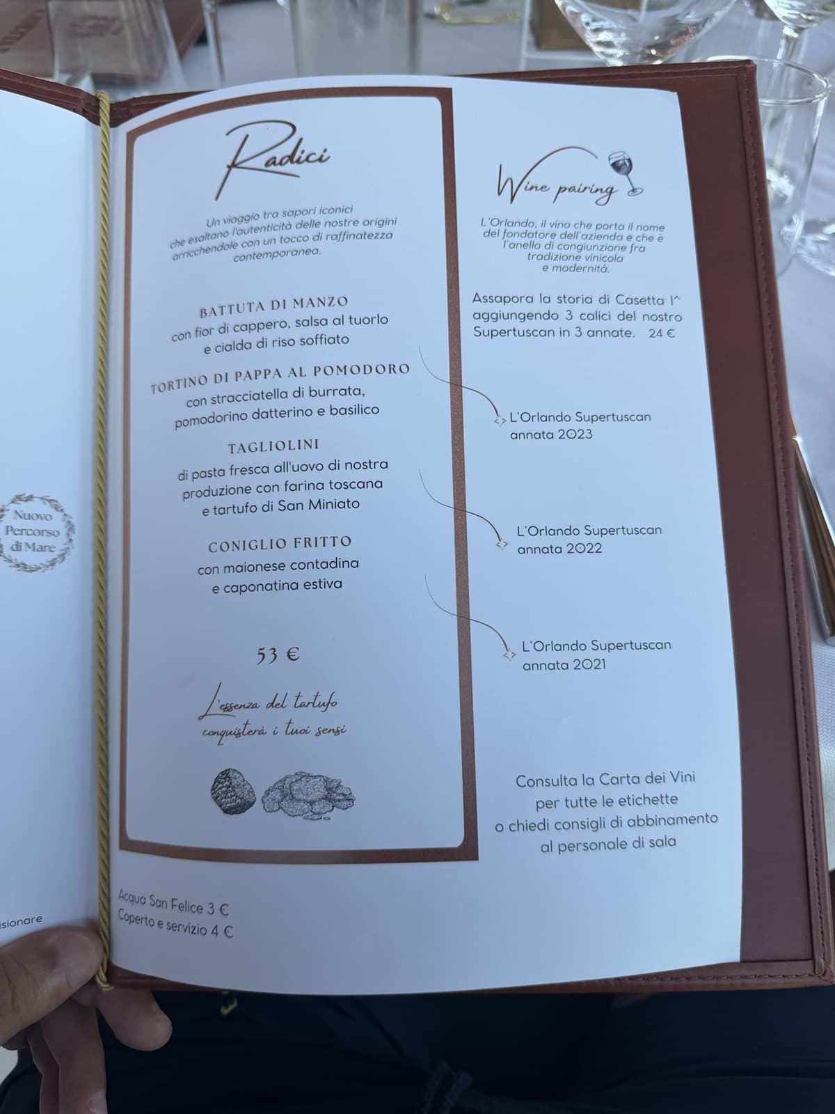 The Radici tasting menu at 53 euro listing battuta di manzo, tortino di pappa al pomodoro, tagliolini and fried rabbit, beside a wine pairing offering three vintages of the estate Supertuscan L Orlando at 24 euro
