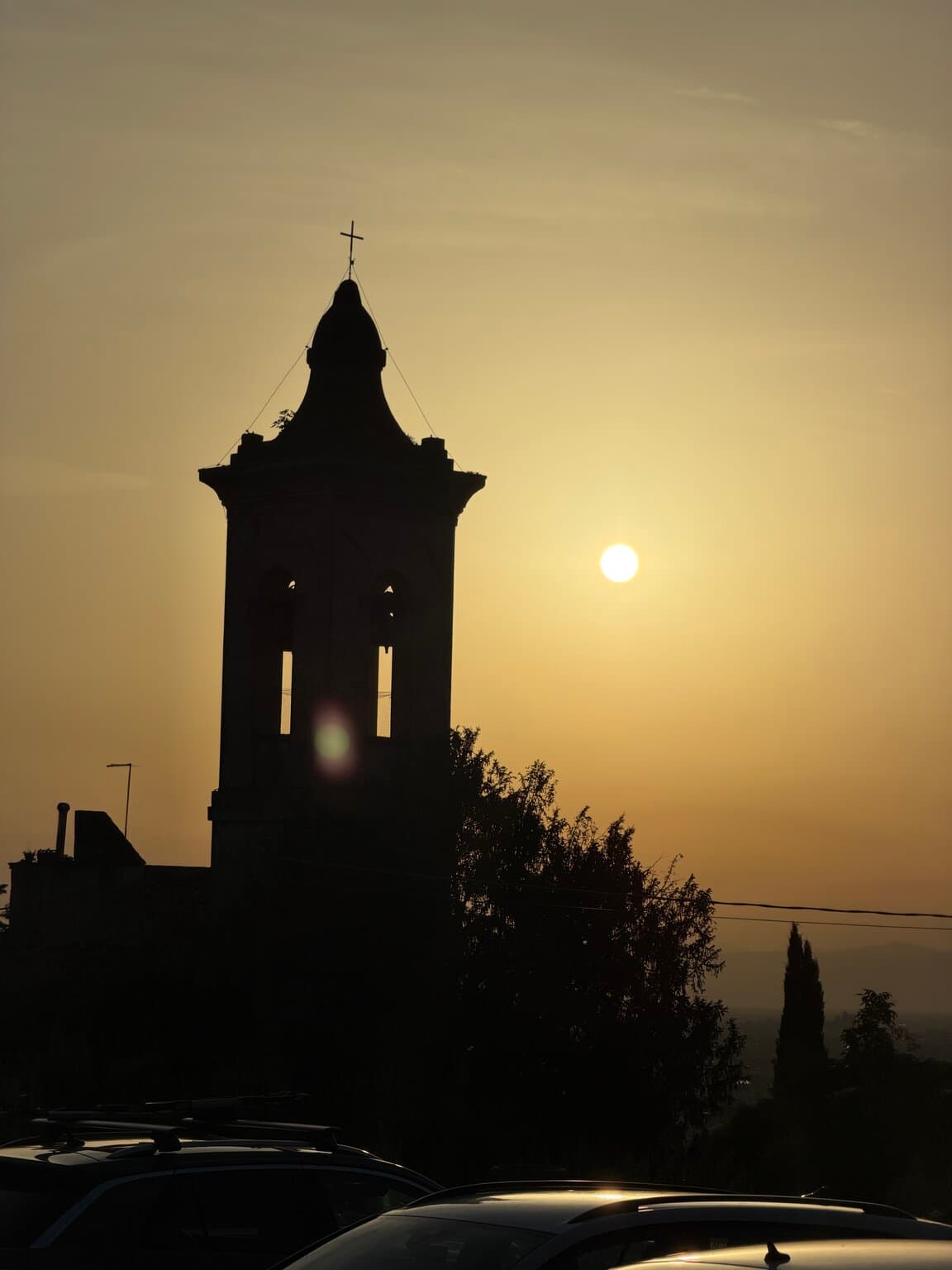 The church bell tower next to La Gargotta silhouetted against the setting sun