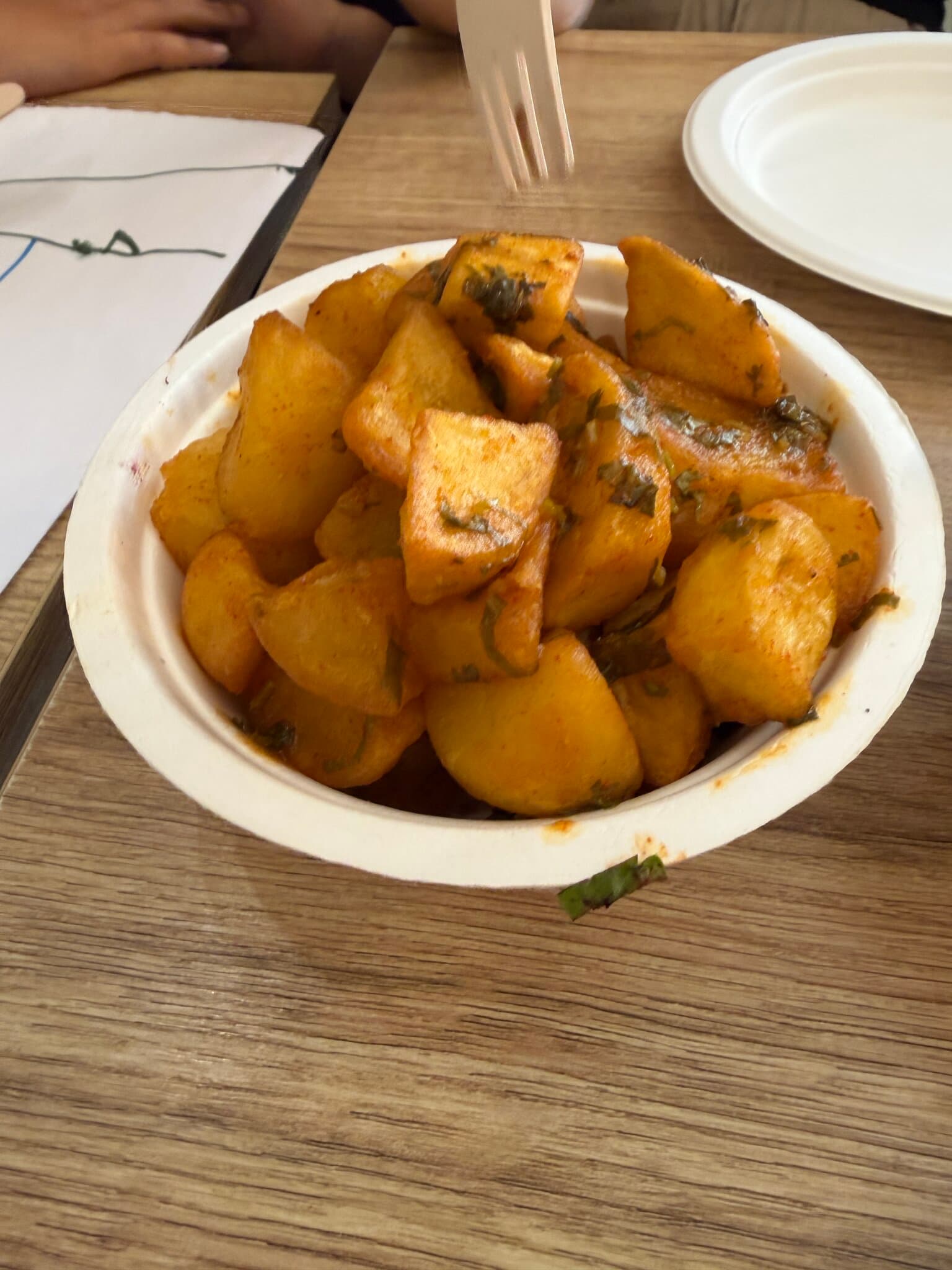 A bowl of batata harra, fried potato cubes with herbs