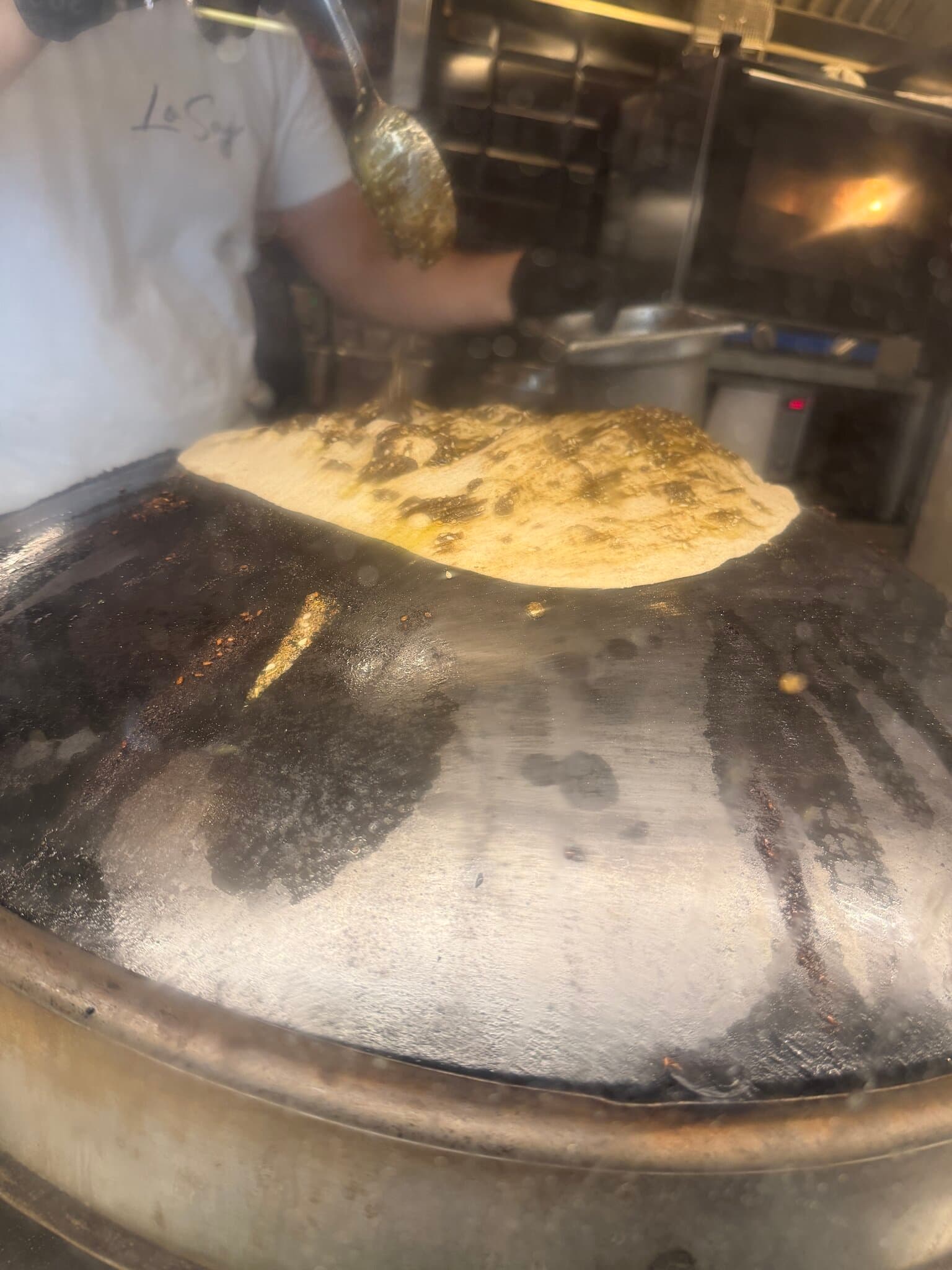 Za'atar flatbread baking on the domed saj griddle